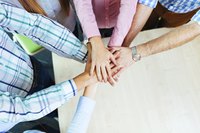 A close-up of co-workers in a team huddle.