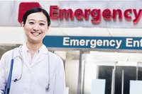 A doctor standing outside of a hospital entrance.