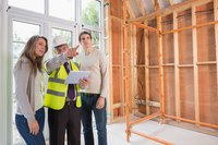 Business owners speaking with construction worker on site