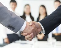 Close-up of company representatives shaking hands in business meeting