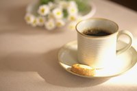 A cup of black coffee with a cookie.