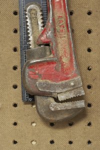 Make a pipe-cutting tool with a monkey wrench.