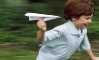 Children love to fly paper airplanes outdoors.