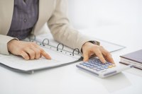Business accountant using calculator at desk.