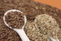 Spoons filled with whole and ground flaxseed.