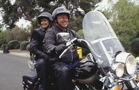 A couple sitting on a bicycle.