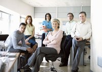 A business team posing for a camera in an office.