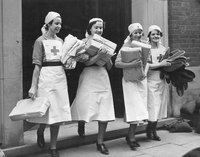 Four British Red Cross nurses carry packages in 1941.