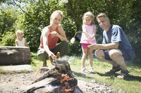 Roasting hot dogs over open flame brings families together.