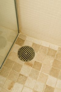 The shower drain is at floor level, so the drain pipe must run beneath.