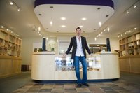 A man stands in front of a counter in a retail space.