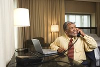 A businessman is working from his hotel room.