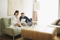 Two people using a laptop at home.