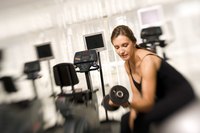 Young woman lifting weights in the gym