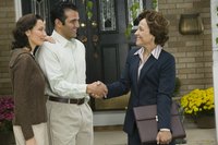 Couple shaking hands with real estate agent.