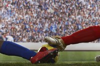 Soccer players in a sliding tackle
