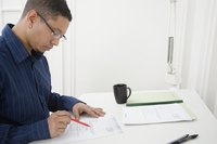 Young adult male writing up paper work