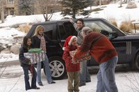 A family unloading gifts from a vehicle at a holiday get together.