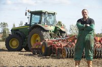 A farmer standing in front of his tractor.