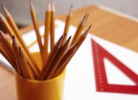 A ruler, pencils and paper on a desk.