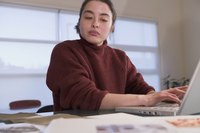 A woman typing on a laptop at her desk.