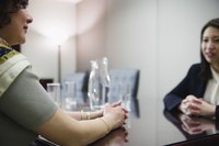 Two businesswoman sit across from one another at a table