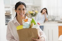 A woman is bringing her groceries into the house.