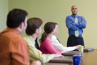 A confident man making a presentation at the front of a conference room.