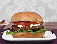 Place grilled portobellos on a burger bun with goat cheese and tomato.