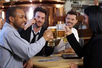 Office workers toasting beers at a pub.