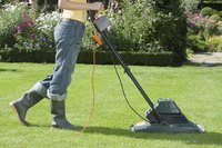 Man using electric lawn mower to cut grass