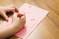 Young child making a Valentine's Day card.