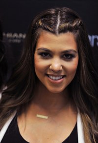 Reality star Kourtney Kardashian wears a princess-length necklace on the red carpet.