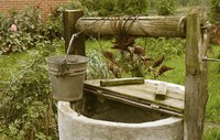 A half covered well with a bucket.
