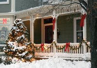 Red and green Christmas decorations on a snowy house.