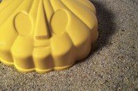 A sand mold of a shell on the beach.