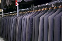 A rack of suits for sale at a shop.