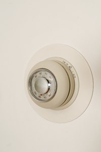 A pneumatic thermostat uses a control to adjust the ambient air temperature.