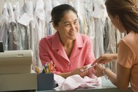 An employee and customer discussing a garment at the dry cleaners.