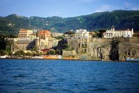 Pastel buildings perch on cliffs over the sea in Sorrento.