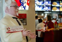 A close-up of an iconic statue of Colonel Sanders inside of a KFC Restaurant.