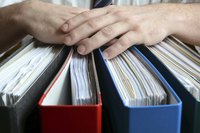Close-up of hands on top of company's spending binders