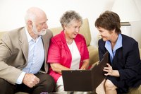 A mature woman and man are having a discussion with an insurance agent.