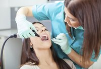 A dentist examines a patient's teeth
