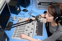 Woman in a radio broadcasting setting.