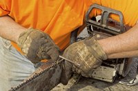 A worker fixing the chain on a chainsaw.