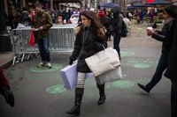 A consumer walking with shopping bags in the city.