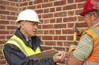 Supervisor with clipboard talking to a contractor.