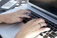A woman is typing on her computer.