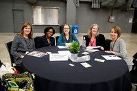 Business women sitting at a table during a sales presentation.